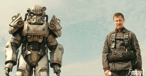 A Man Standing Next To A Robot With The Word Fallout On The Bottom Right GIF