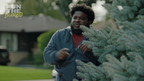A Man Standing Next To A Tree With The Words Run The Burbs Written On The Bottom GIF