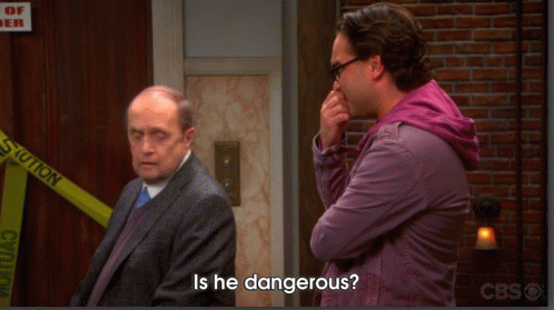 A Man Standing Next To Another Man With The Words Is He Dangerous On The Bottom GIF