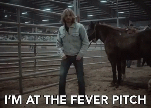 A Man Standing Next To Two Horses With The Words I 'M At The Fever Pitch GIF