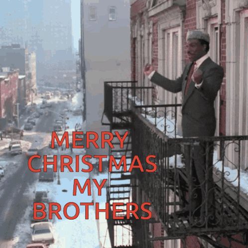 A Man Standing On A Balcony With The Words Merry Christmas My Brothers GIF