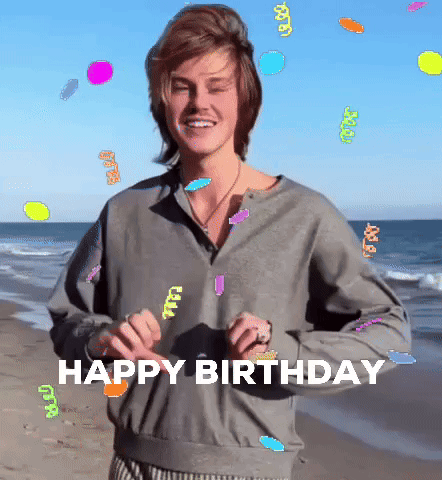 A Man Standing On A Beach With The Words Happy Birthday Written On It GIF