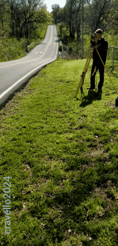 A Man Standing On A Grassy Hill Next To A Road With The Words Gravelozzi24 Written On The Bottom GIF