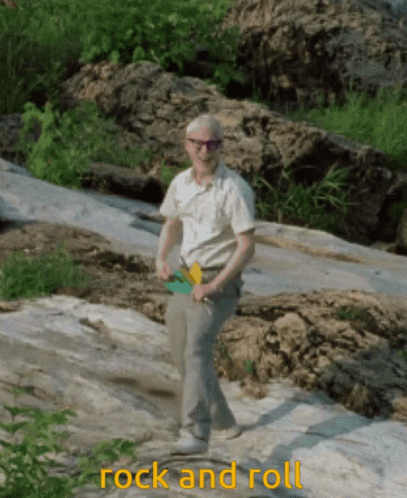 A Man Standing On A Rock With The Words Rock And Roll Written Below Him GIF
