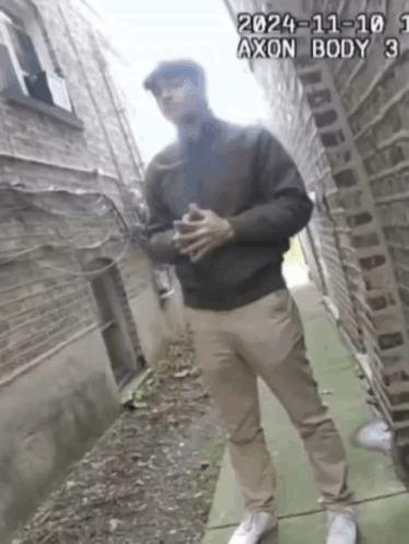 A Man Standing On A Sidewalk With The Date 2024-11-101 GIF