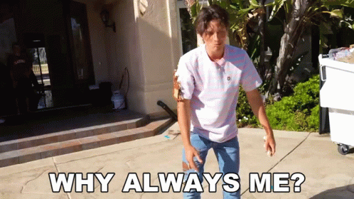 A Man Standing On A Sidewalk With The Words " Why Always Me " Written On It GIF