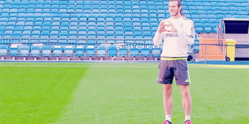 A Man Standing On A Soccer Field Wearing A Shirt That Says Emirates On It GIF
