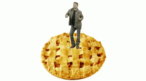 A Man Standing On Top Of A Large Pie GIF