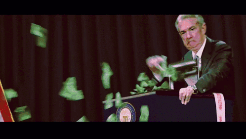 A Man Stands At A Podium While Money Falls From The Sky GIF
