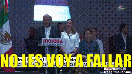 A Man Stands At A Podium With A Morena Sign Behind Him GIF