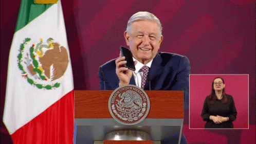 A Man Stands At A Podium With A Seal That Says Mexicanos Unidos Mexicanos GIF