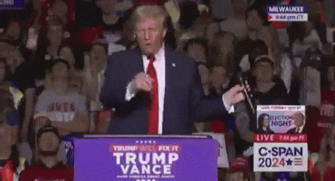 A Man Stands At A Podium With A Sign That Says Trump Vance GIF