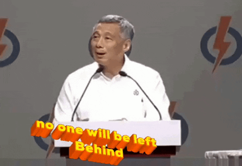 A Man Stands At A Podium With The Words No One Will Be Left Behind GIF
