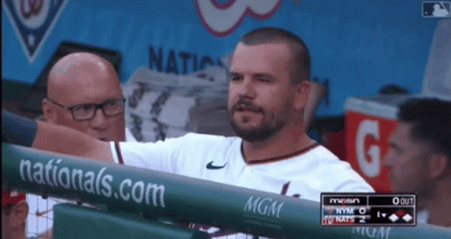 A Man Stands Behind A Fence With A Nationals.com Banner On It GIF