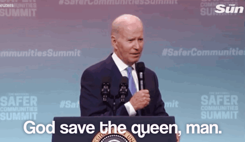 A Man Stands Behind A Podium With The Words God Save The Queen Man GIF