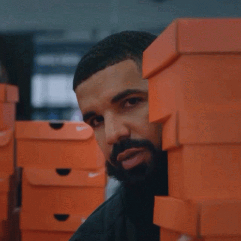 A Man Stands Behind A Stack Of Nike Boxes GIF