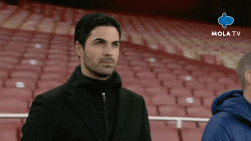A Man Stands In An Empty Stadium With Mola Tv Written On The Bottom Right GIF