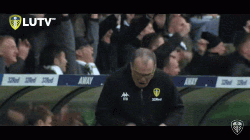 A Man Stands In Front Of A Banner That Says Away On It GIF