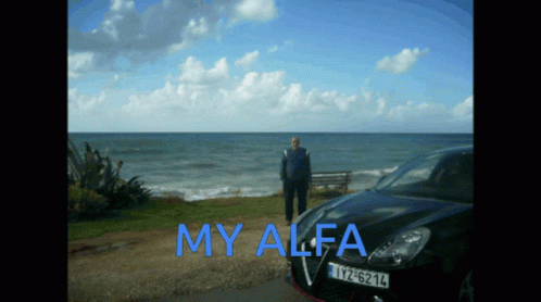 A Man Stands In Front Of A Black Car That Says My Alfa On The Side GIF