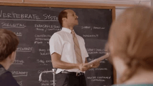 A Man Stands In Front Of A Blackboard With The Word Vertebrate Written On It GIF