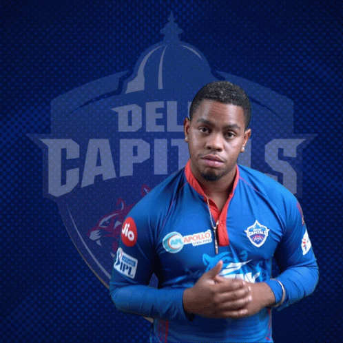 A Man Stands In Front Of A Blue Background With The Word Del Capitals On It GIF