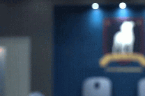 A Man Stands In Front Of A Blue Wall With A Painting Of A Dog On It GIF