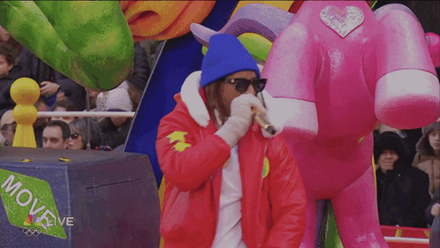 A Man Stands In Front Of A Box That Says Move Live On It GIF