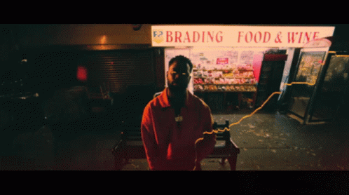 A Man Stands In Front Of A Brading Food And Wine Store GIF