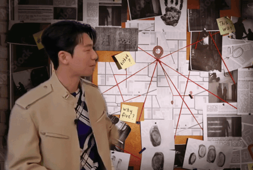 A Man Stands In Front Of A Bulletin Board With A Sticky Note On It That Says " Why Five " GIF