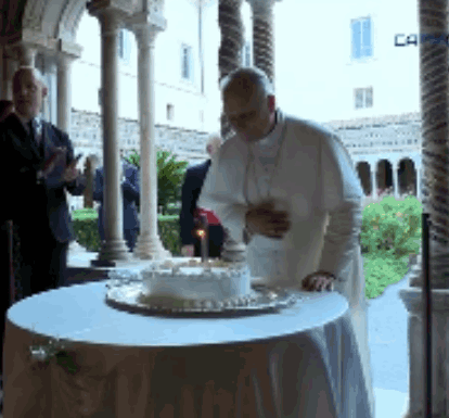 A Man Stands In Front Of A Cake With A Candle On It GIF