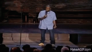A Man Stands In Front Of A Crowd Holding A Microphone And Dancing GIF