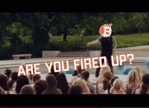 A Man Stands In Front Of A Crowd With The Words " Are You Fired Up " Above Him GIF