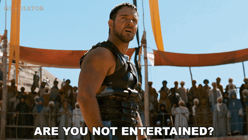 A Man Stands In Front Of A Crowd With The Words Are You Not Entertained GIF