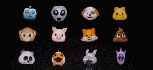A Man Stands In Front Of A Display Of Cartoon Faces GIF