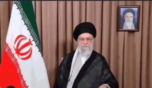 A Man Stands In Front Of A Flag With A Greek Key Pattern GIF