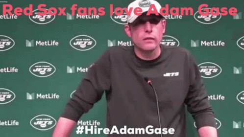 A Man Stands In Front Of A Green Wall That Says Metlife Jets GIF