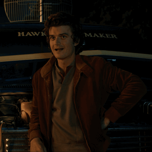 A Man Stands In Front Of A Hawk Maker Vehicle GIF