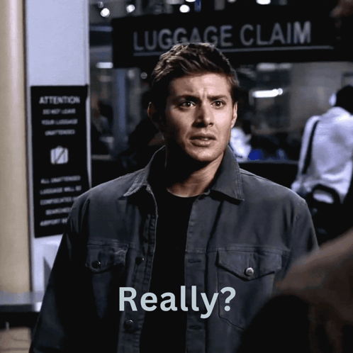 A Man Stands In Front Of A Luggage Claim Sign And Says Really GIF