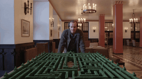 a man stands in front of a maze with the letters zzz on the ceiling