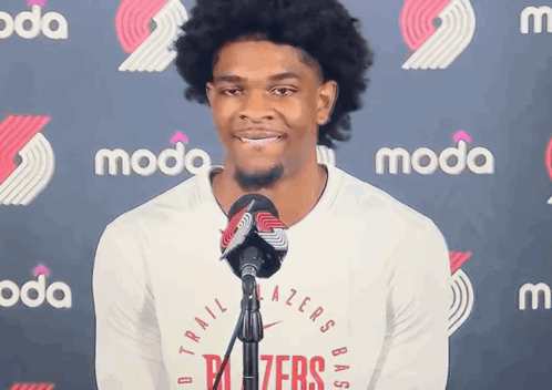 A Man Stands In Front Of A Microphone Wearing A Trailblazers Shirt GIF