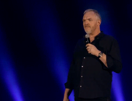 A Man Stands In Front Of A Microphone With The Words Gut Instinct Says " No " Above Him GIF