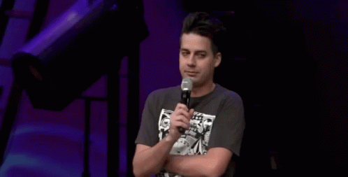 A Man Stands In Front Of A Microphone With The Words I Ain 'T Prayin ' For That Behind Him GIF