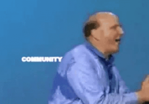 A Man Stands In Front Of A Microsoft Community Windows Sign GIF