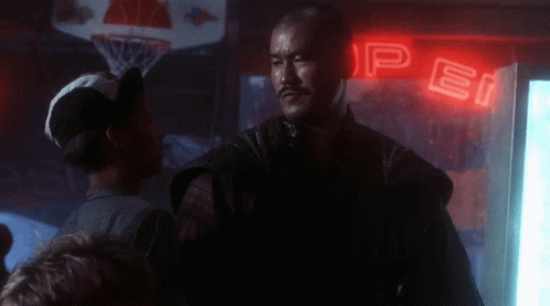 a man stands in front of a neon sign that says pepsi