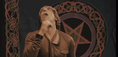 A Man Stands In Front Of A Pentagram With A Celtic Knot Around It GIF