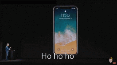 A Man Stands In Front Of A Phone That Says 11:32 On The Screen GIF