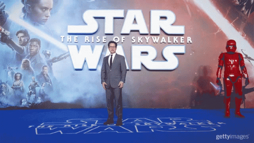 A Man Stands In Front Of A Poster For Star Wars GIF