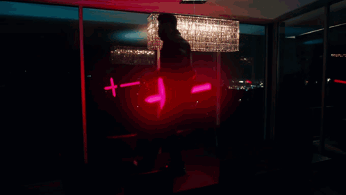 A Man Stands In Front Of A Poster That Says Madness On It GIF