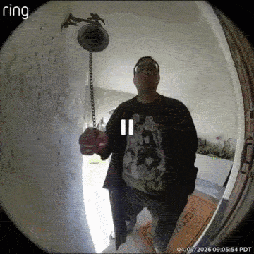 A Man Stands In Front Of A Ring Doorbell Holding A Bell GIF