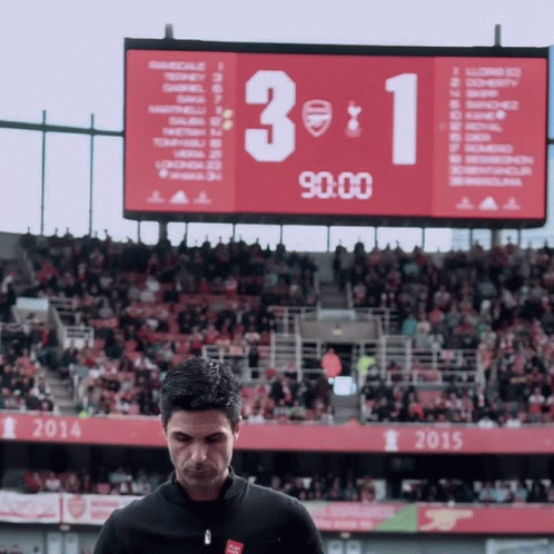 A Man Stands In Front Of A Scoreboard That Shows The Score Of 3 To 1 GIF
